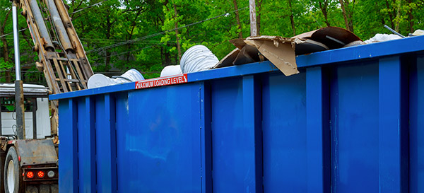 full roll off dumpster being picked loaded onto truck