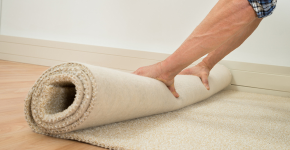 Person rolling up carpet