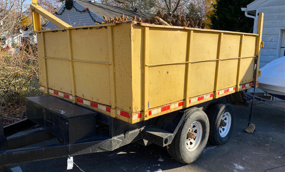 trailer dumpster sitting in residential driveway