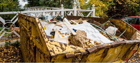 yellow 10 yard dumpster backed up to yard