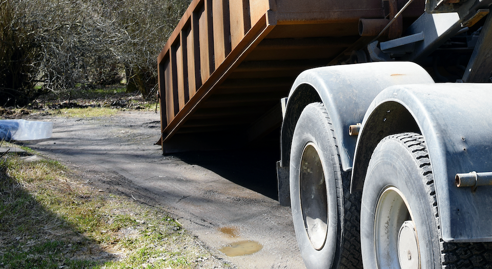 dumpster being dropped off in driveway