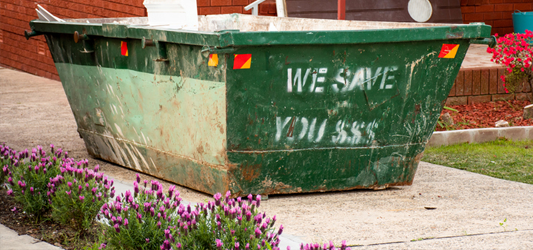 green dumpster on residential driveway