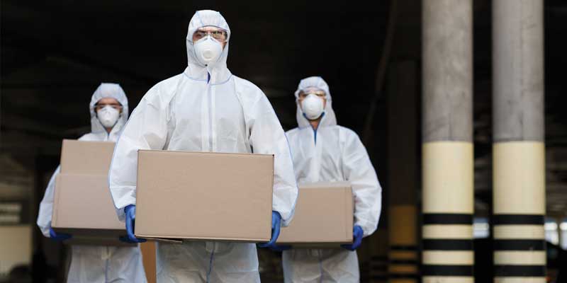 hoarding cleanup workers dressed in hazmat suits carrying boxes