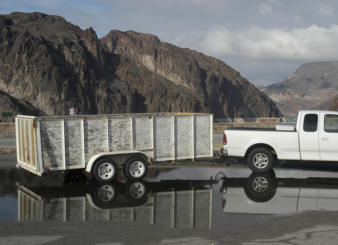 Trailer dumpster on wheels hitched to truck