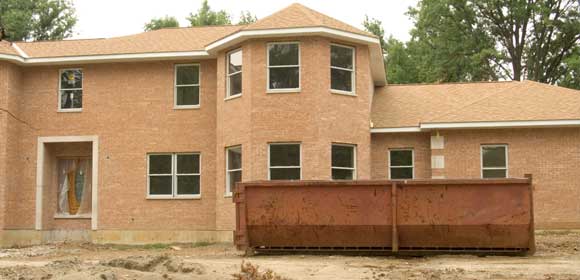 dumpster in front of house under construction