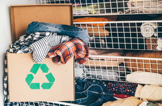 Cardboard recycling box full of used clothes and textiles