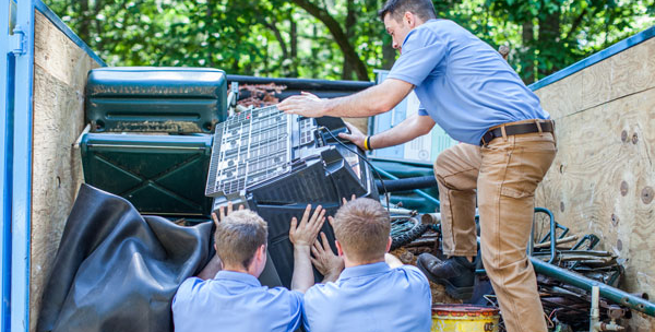 Junk removal crew loading dumpster