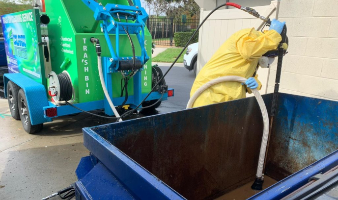 Worker cleaning out a commercial dumpster