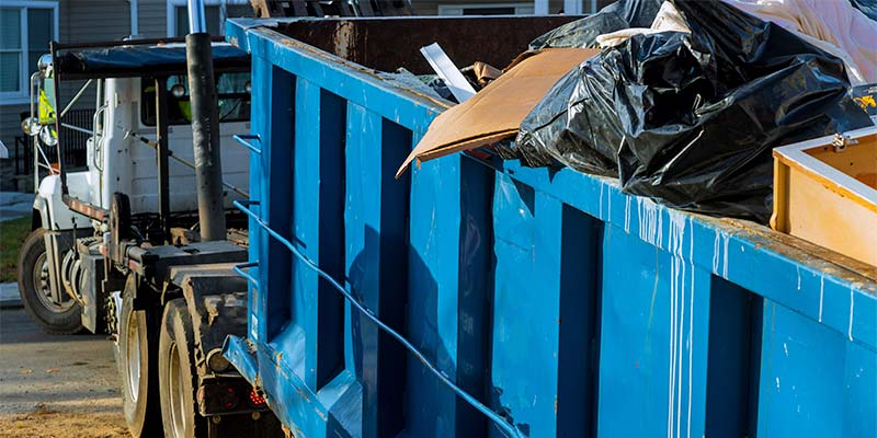 full dumpster on truck being hauled away