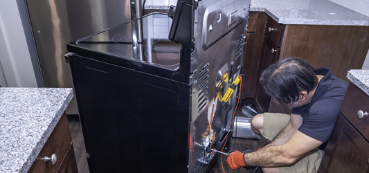 junk removal pro disconnecting an oven in kitchen