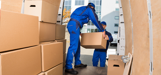 Junk removal crew loading vehicle with boxes