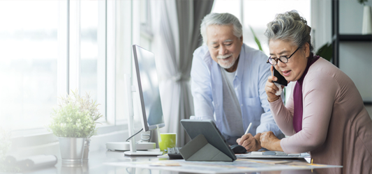 Couple looking at computer while on the phone