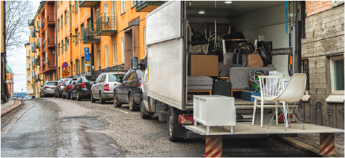 junk removal truck full of furniture in front of apartment