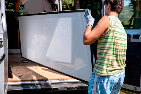 man loading television into back of van