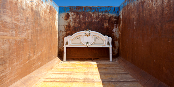 headboard in empty roll-off dumpster