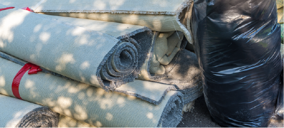 carpet rolls and trash bags piled up