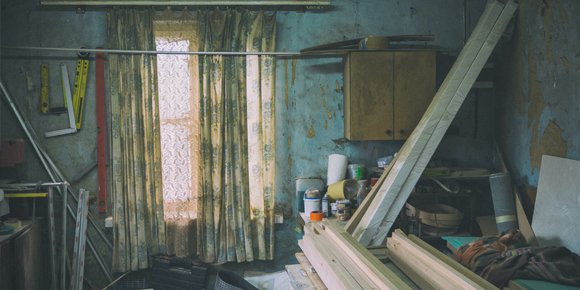 dimly lit room with dirty walls and clutter