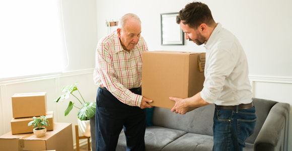 Son helping elderly father move boxes