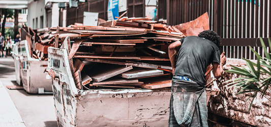 man loading debris into dumpster