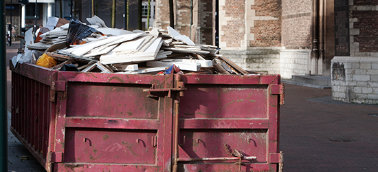 construction dumpster full of debris on a worksite 