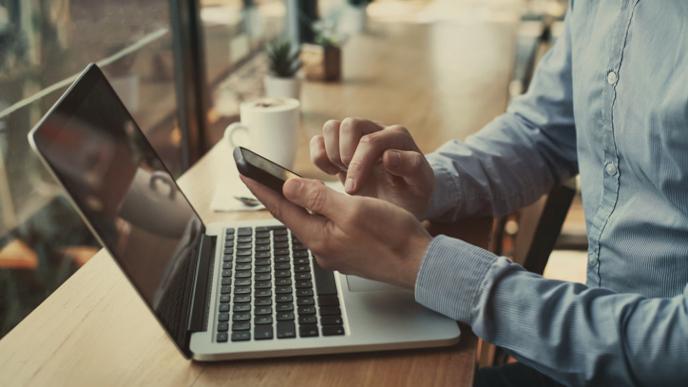 Man using phone and laptop